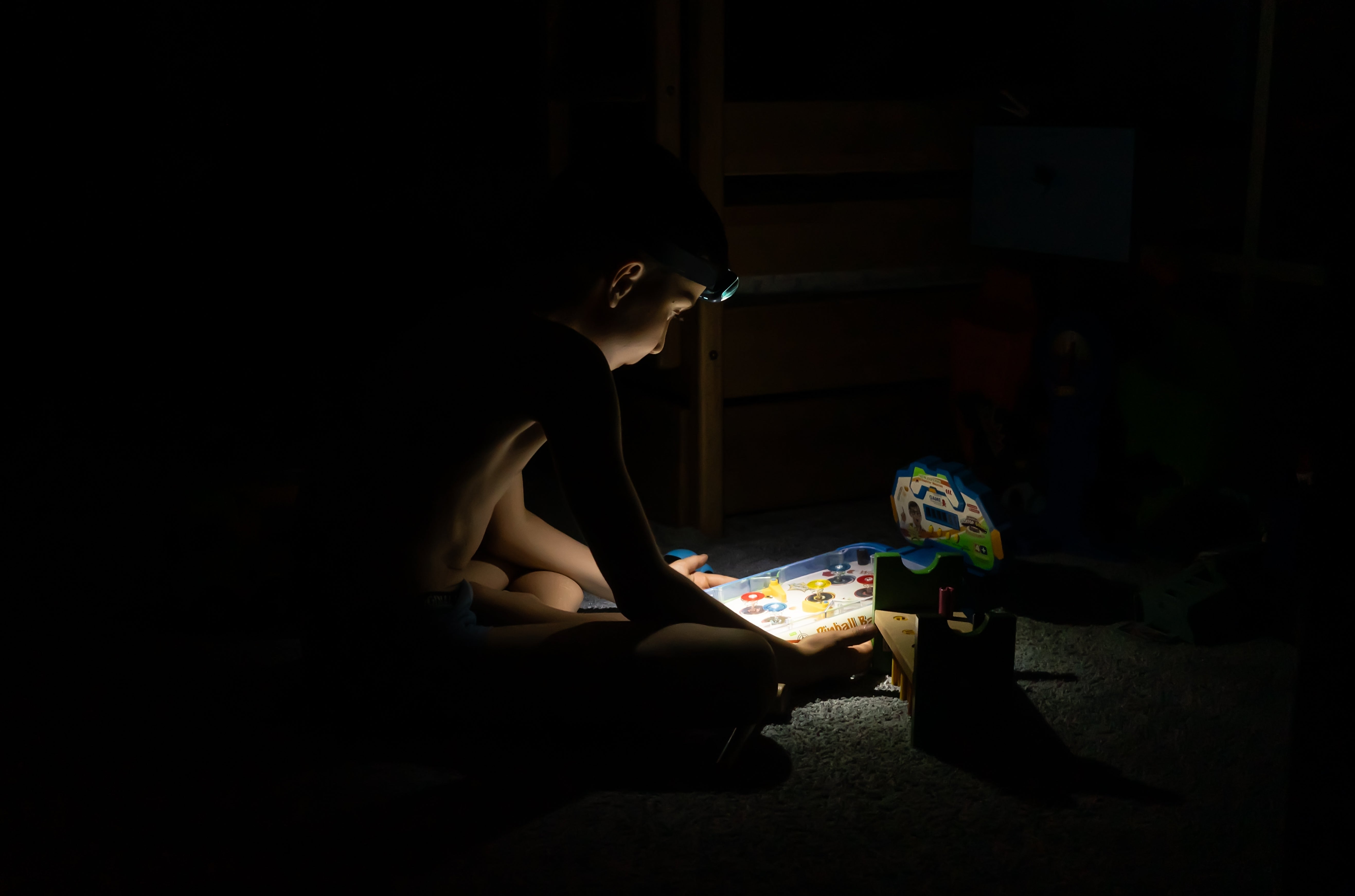 Imagem de um menino a brincar, às escuras; durante um apagão em Kiyv, na Ucrânia. Créditos: shutterstock