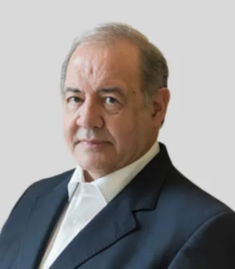 Retrato de António Costa Silva, antigo ministro da Economia e do Mar, sobre um fundo cinzento claro.