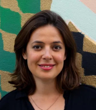 Retrato da politóloga Susana Coroado, sobre uma parede com desenhos.