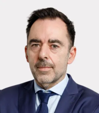Retrato do comentador desportivo Carlos Freitas sobre um fundo cinza claro.