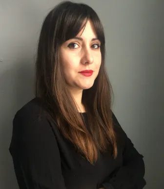 Imagem de uma mulher jovem, a psicóloga Ensaio Ludmila D. Nunes, sob um fundo neutro. D/R.