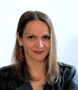 Retrato a cores de Madja Ruge, investigadora sénior no programa do ECFR. Fundo claro.