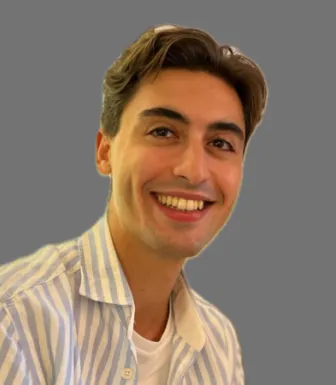 Um homem com 25 anos, de camisa de riscas sob fundo neutro. D/R.