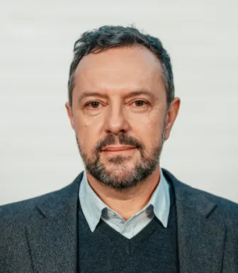 Retrato do politólogo Pedro Magalhães sobre um fundo cinzento claro.