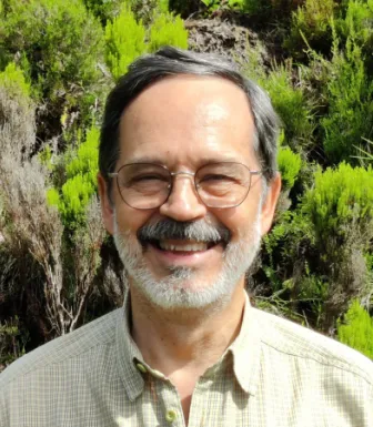 Retrato do biológo Jorge Palmeirim, com vegetação a servir de fundo