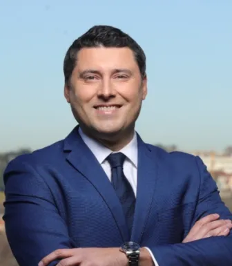 Retrato de Pedro Carvalho da Silva, especialista em comunicação na Faculdade de Economia do Porto, com uma paisagem ao fundo.