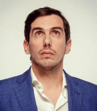 Retrado do humorista Cláudio Almeida a olhar para cima.