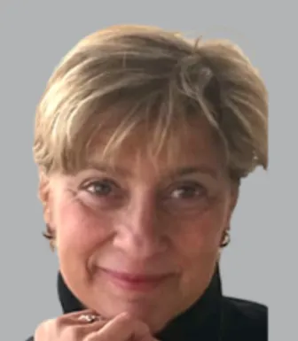 Retrato a cores da economista Isabel Grilo. Fundo cinzento.