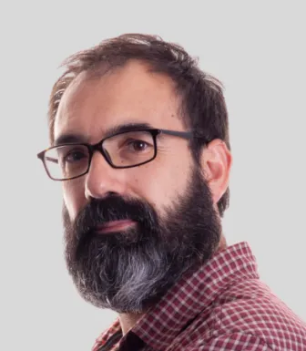 Retrato a cores de um homem, o escritor Abel Coentrão, vestido com uma camisa aos quadrados.