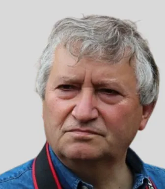 Retrato a cores de um homem, o arqueólogo António Martinho Baptista, com o cabelo grisalho.