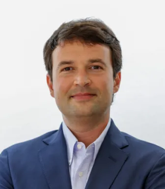 Retrato a cores de um homem, o professor Armando Rocha. Fundo claro.