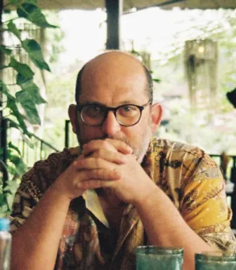 Retrato de um homem, vestido com uma camisa com desenhos. 