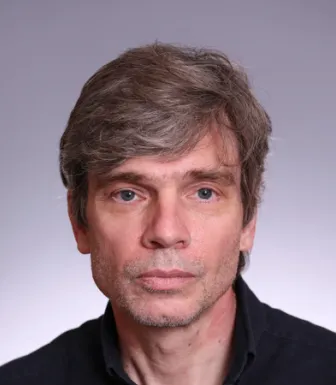 Retrato a cores de um homem, Richard Youngs, vestido com uma camisa preta.