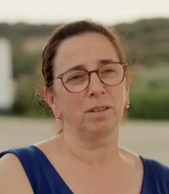 Retrato de uma mulher de óculos e cabelo atado. Ambiente rural. DR/FFMS