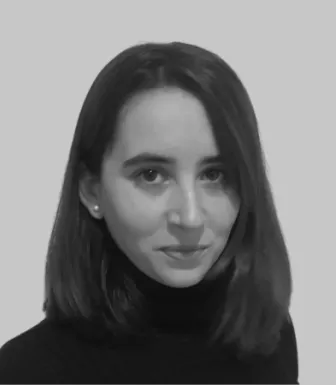 Retrato a preto e branco de uma mulher jovem, com cabelo pelos ombros, vestida com uma camisola preta.