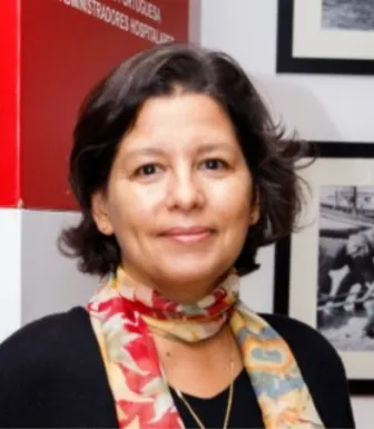 Retrato a cores de uma mulher sorridente, veste uma camisola preta e usa um lenço colorido.