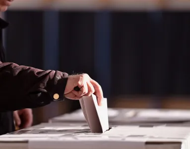 Imagem de um senhor a colocar o voto numa urna