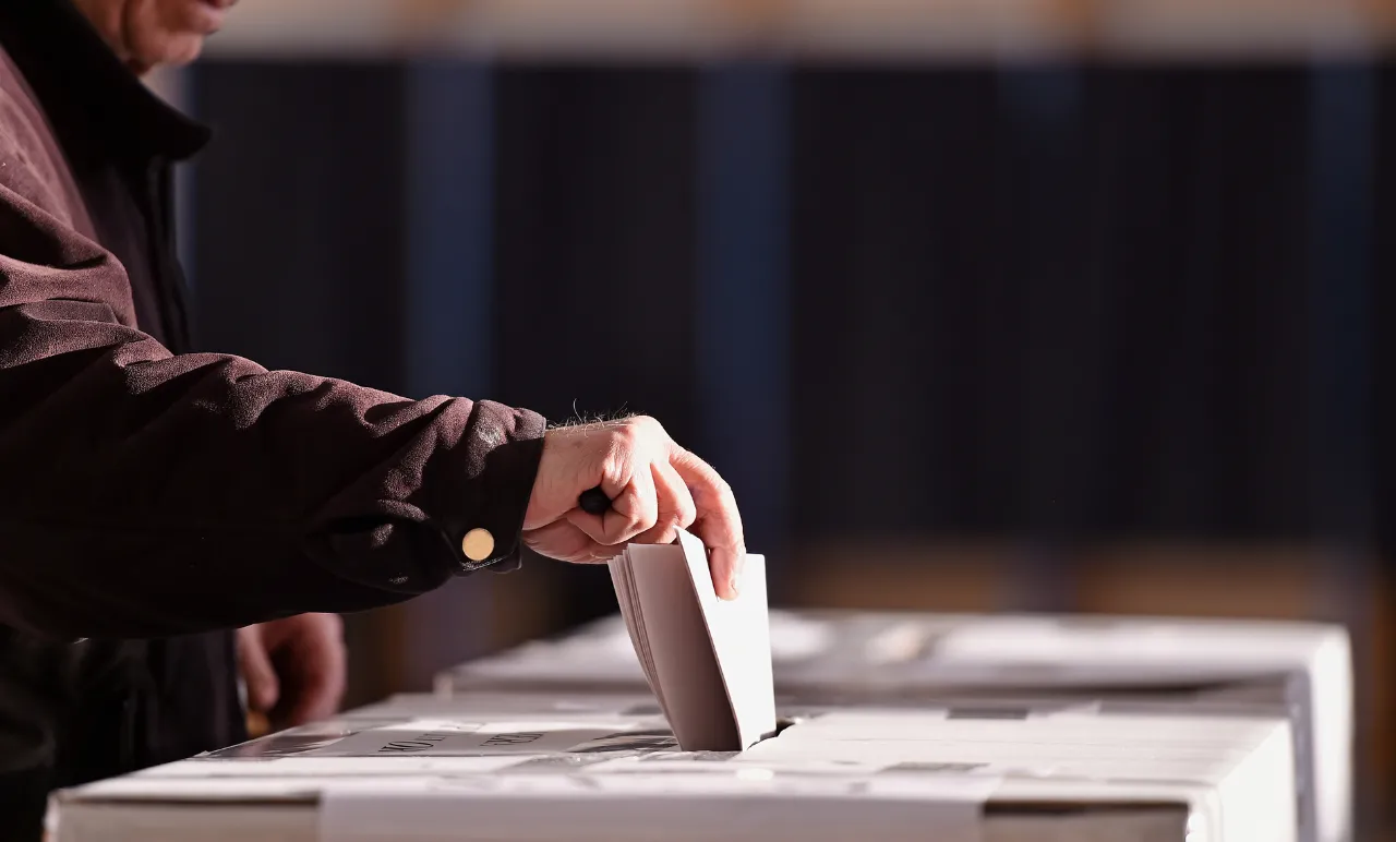 Imagem de um senhor a colocar o voto numa urna