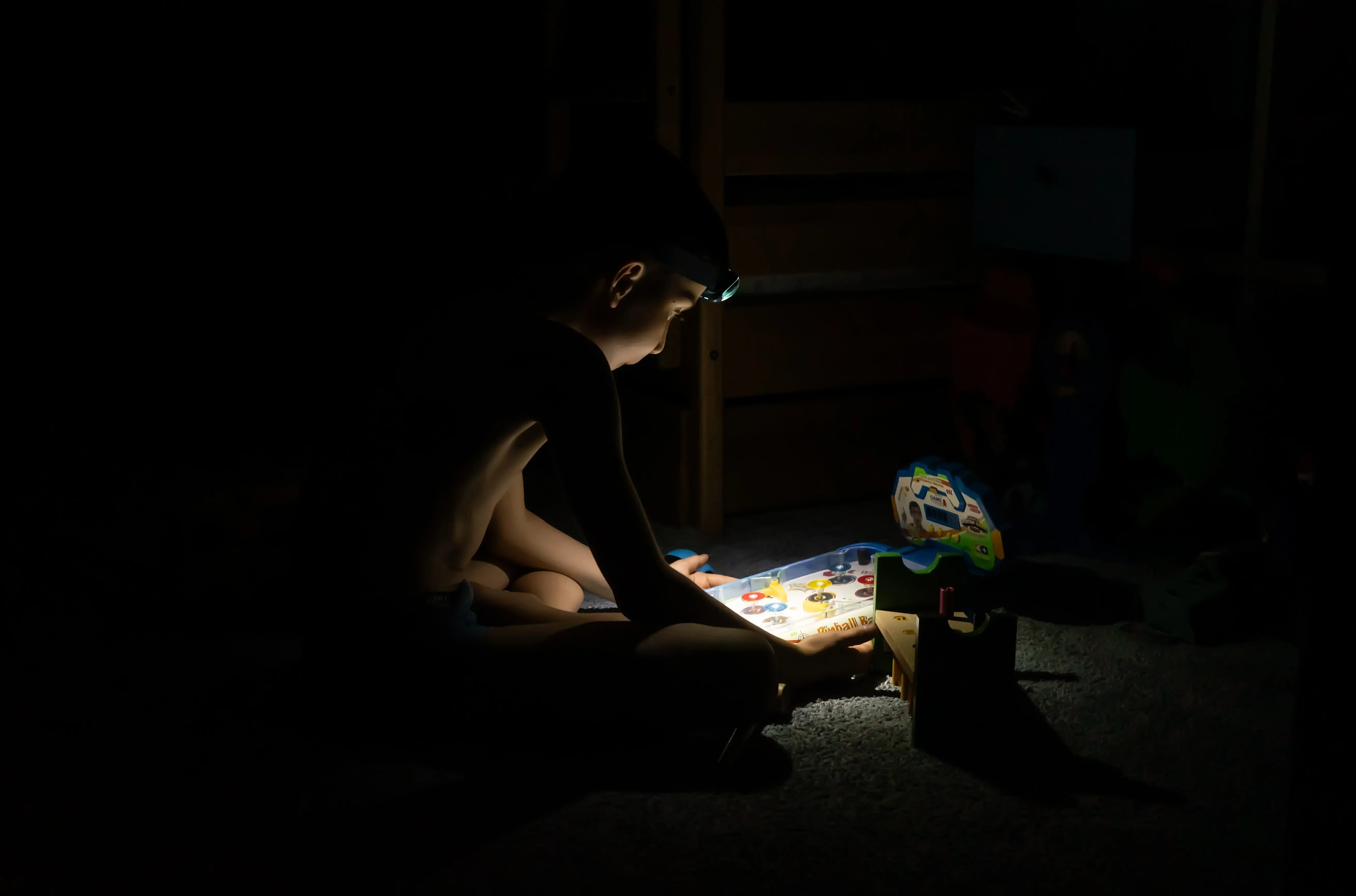 Imagem de um menino a brincar, às escuras; durante um apagão em Kiyv, na Ucrânia. Créditos: shutterstock