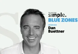 Retrato a preto e branco de Dan Buettner, com texto "BLUE ZONES" ao lado.