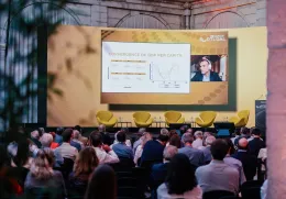 Conferência com várias pessoas a olhar para uma tela com Thomas Philippon.