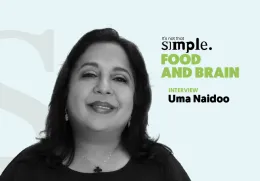Retrato a preto e branco da psiquiatra nutricional Uma Naidoo sobre um fundo azul claro. Texto: "It's not that simple. Food and Brain. Interview".