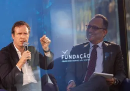 Imagem de duas fotografias sobrepostas: do lado direito o entrevistador, do lado esquerdo, o entrevistado. Ao centro, o logotipo da Fundação.