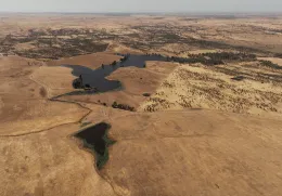Imagem aérea de vários terrenos áridod r algumas manchas de água.
