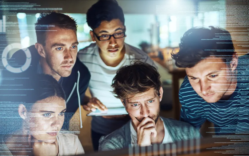 Imagem de um grupo de jovens a ver programação informática
