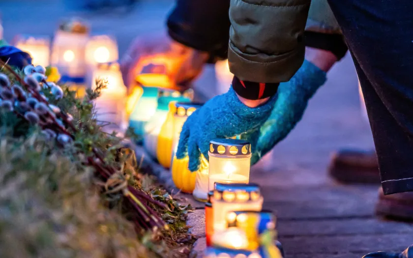 Imagem de uma pessoa a colocar velas em memória dos mortos