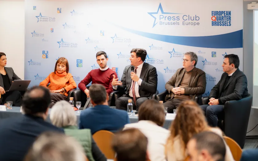 Uma plateia a ouvir, ao fundo, os autores do livro da Fundação «Trabalho Forçado», sentados, lado a lado.