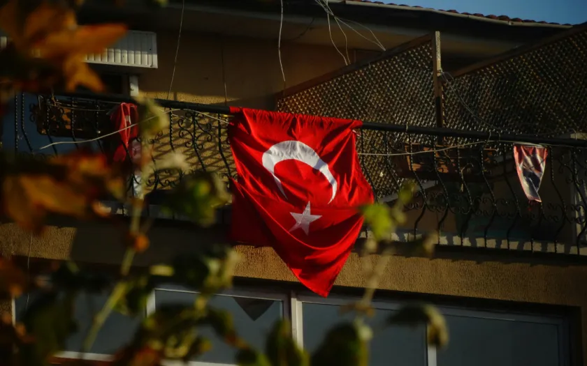 Uma bandeira da Turquia pendurada numa varanda.