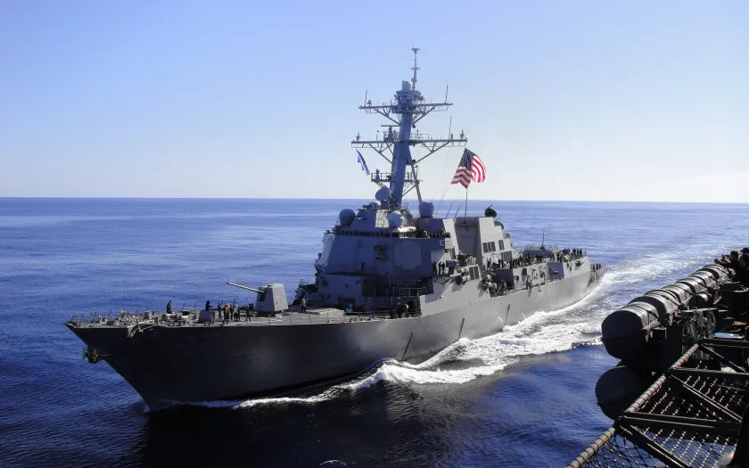Imagem de um barco da marinha americana, com uma bandeira dos EUA hasteada.