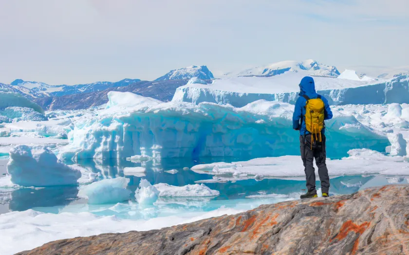 Um homem, explorador, olha para um icebergue no Ártico. Crédito: Shutterstock