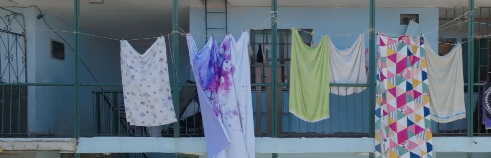 Imagem de roupa estendida ao sol, num prédio de pessoas desfavorecidas