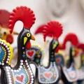 Imagem de várias figuras em barro do galo de Barcelos, numa loja de artigos para turistas.