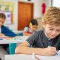 Alunos do ensino básico na sala de aula a fazer testes. Crédito:Shutterstock