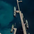 Imagem aérea de barcos e água, no porto de carga de Doha, Qatar.