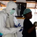 Imagem de uma enfermeira e de um médico vestidos com equipamentos de segurança durante um surto de Ébola em África. Belen B. Massieu/shutterstock