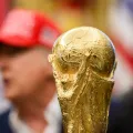 Imagem do troféu do Mundial 2026 em foco e, ao fundo, desfocado, Donald Trump. Créditos: shutterstock