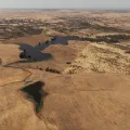Imagem aérea de vários terrenos áridod r algumas manchas de água.