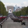 Desfile na avenida Champs-Elysees, em Paris, no dia da Bastilha. Soldados a desfilar e várias bandeiras do país.