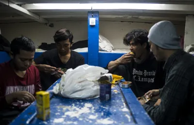 Imagem de pescadores indonésios a tomar uma refeição no interior de um barco de pesca. Crédito: Daniel Rodrigues