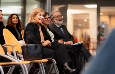 A presidente, a diretora-geral e o diretor de publicações da Fundação, sentados, a assistir à apresentação do livro «O Trabalho Forçado».
