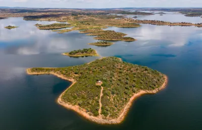 Vita aérea da barragem do Alqueva, sob um céu com nuvens. Crédito: Paulo Resende/Canva