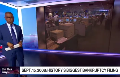 Imagem de um homem, de fato, a apresentar uma reportagem sobre  a falência do Lehman Brothers, em Nova Iorque. Crédito: Imagem extraída da Bloomberg Television