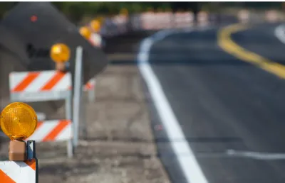 Uma autoestrada em construção, com barreiras de sinalização luminosas. Crédito: Canva