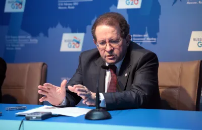 Um homem de meia idade, de óculos, vestindo fato e gravata, está sentado a uma mesa e fala para uma audiência. É o português  Vítor Constâncio, vice-presidente do Banco Central Europeu.  Crédito: Shutterstock 