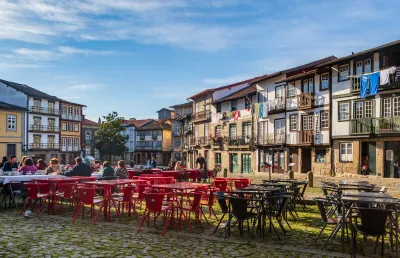 Praça portuguesa em pedra rodeada de casas antigas coloridas, Guimarães é Capital Europeia da Cultura.. Crédito Shutterstock.