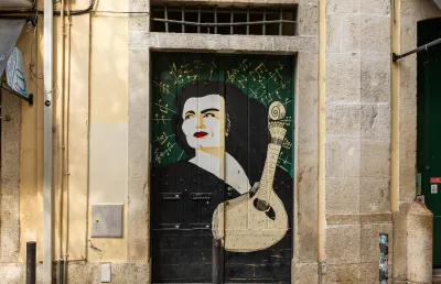 Numa porta de Lisboa foi pintada uma imagem da fadista Amália Rodrigues, junto a uma guitarra. Crédito: Shutterstock 